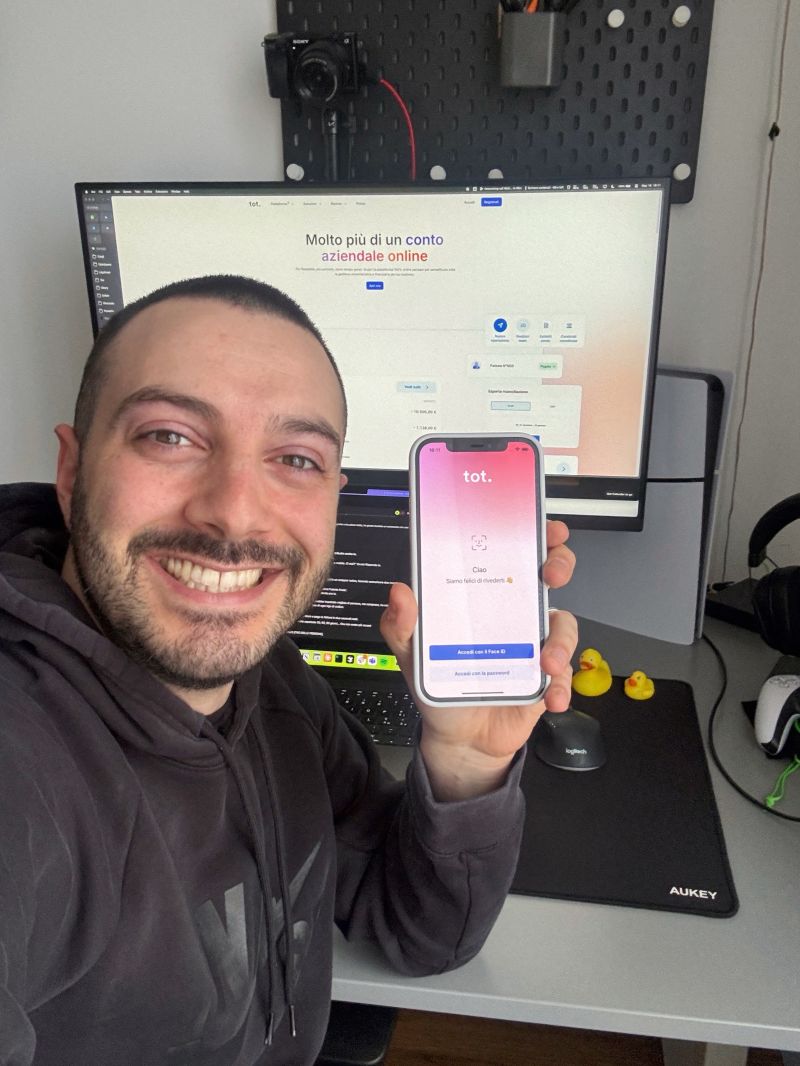 Christian holding the Tot app with the Tot web platform in the background